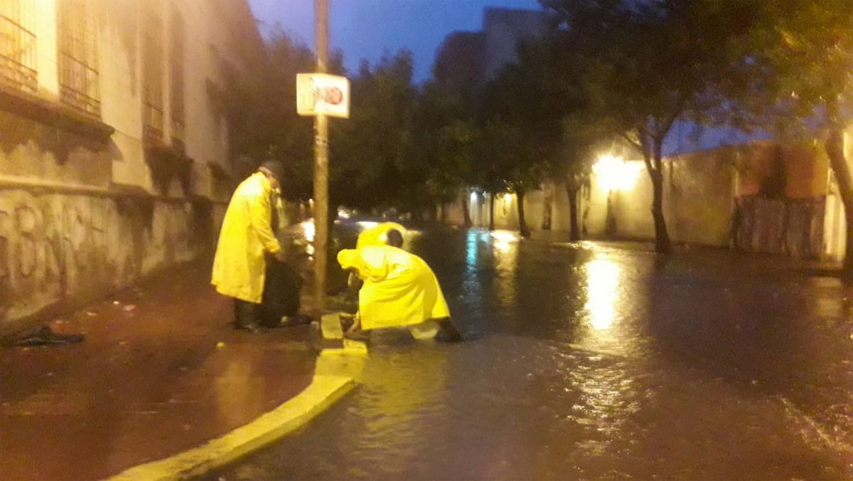 Trabajadores limpian los desagües durante la tormenta